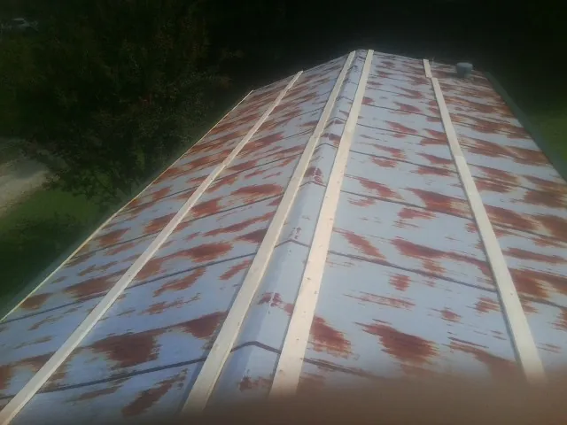 Rusted metal roof panels with new wood purlins before replacement — Storm Damage Roof Repair in Huntingtown by Roofing Brothers