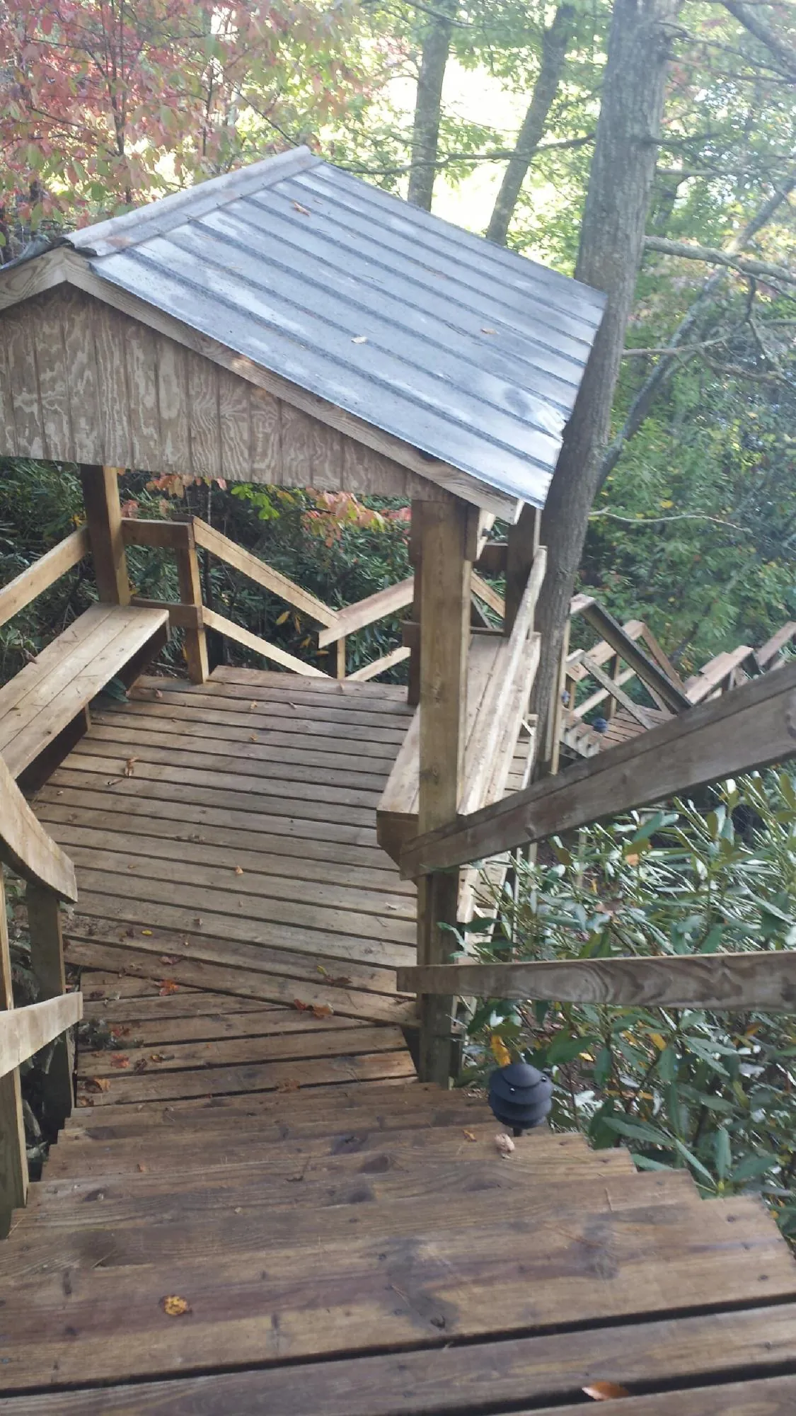 Metal roofed shelter over wooden steps on a wooded walkway — Skylight Repair & Installation work by our crew in Huntingtown
