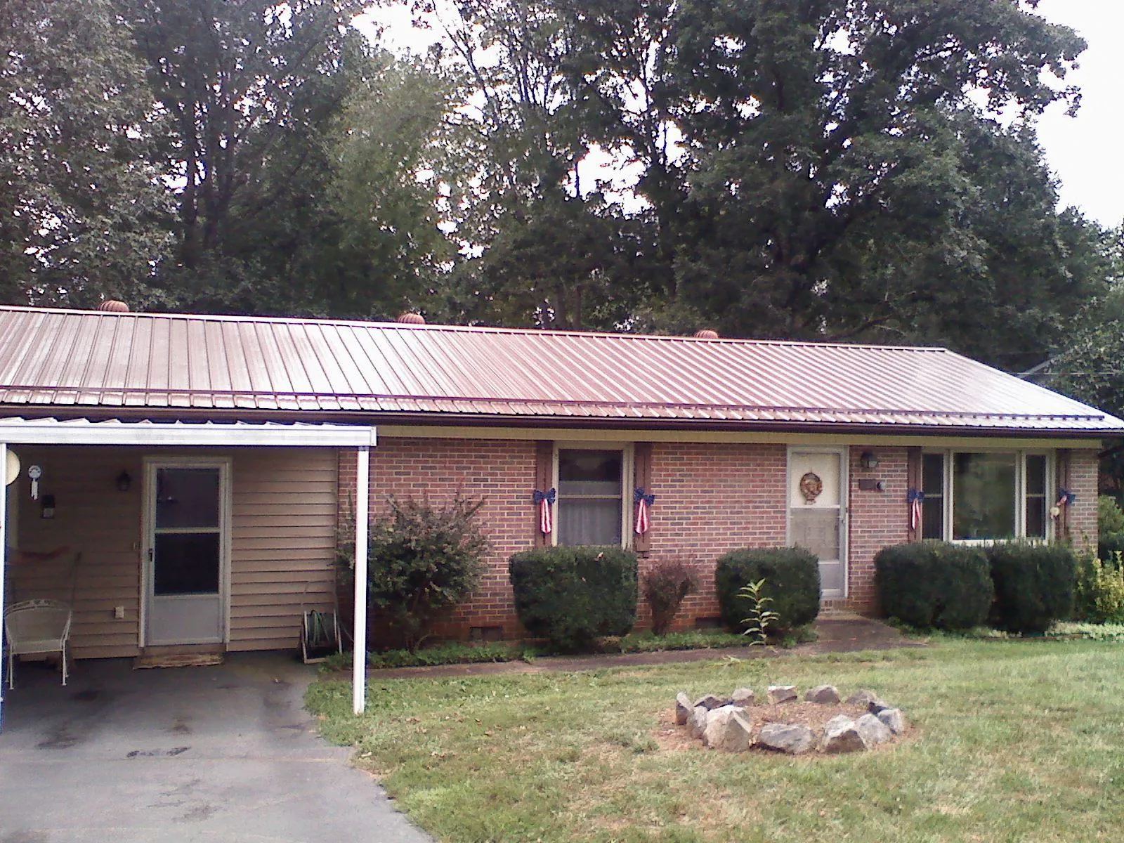 Bronze metal roof and carport on a brick ranch home — Roof Repair work by our crew in Huntingtown
